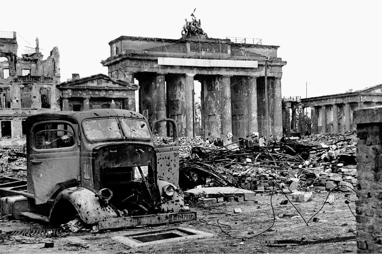 Schwarz-Weiß-Aufnahme des Schutts und der Kriegszerstörung rund um das Brandenburger Tor inklusive eines Autofracks.