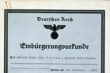 Ausschnitt der Einbürgerungsurkunde „Deutsches Reich“ für Herbert Ernst Karl Frahm, genannt Willy Brandt. Zu sehen ist noch der Reichsadler, lediglich das Harkenkreuz wurde händig übermalt.