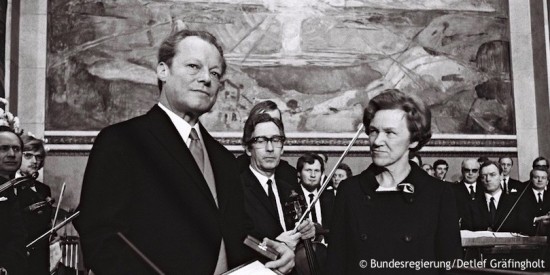 Willy Brandt wird die Urkunde und die Medaille des Friedensnobelpreises von Aase Lionæs in Oslo überreicht. Fotografie in Schwarz-Weiß. Öffnet weitere Informationen zu Brandts Ost- und Deutschlandpolitik.