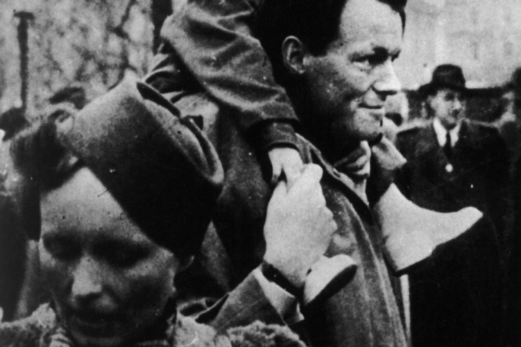 Schwarz-Weiß-Aufnahme aus dem Jahr 1944 auf der Willy Brandt seine Tochter Ninja auf den Schultern trägt. Davor ist seine Frau Carlota zu sehen.