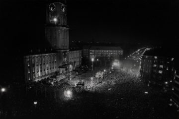 Schwarz-Weiß-Luftaufnahme des Rathaus Schönebergs mit der Trauerkundgebung für den ermordeten US-Präsidenten John F. Kennedy im Jahr 1963.